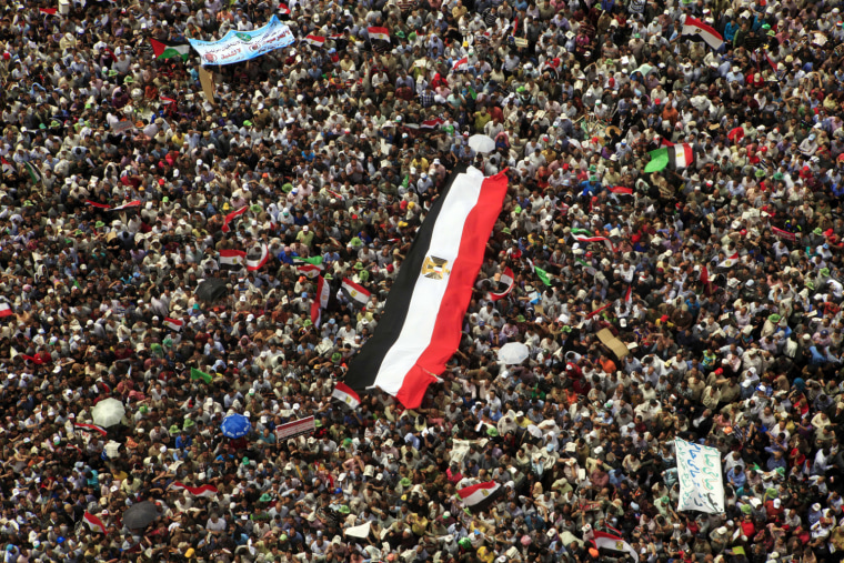 Egyptian protesters hold a giant Egyptian flag during a rally in Tahrir Square to denounce the presidential candidacies of Hosni Mubarak-era officials, including that of his former spy chief in Cairo, Egypt, on April 13. Supporters of the country's most influential political group, the Muslim Brotherhood, along with ultraconservative Salafis and other Islamists packed the capital's Tahrir Square, which was the epicenter of the uprising that ousted Mubarak a year ago.