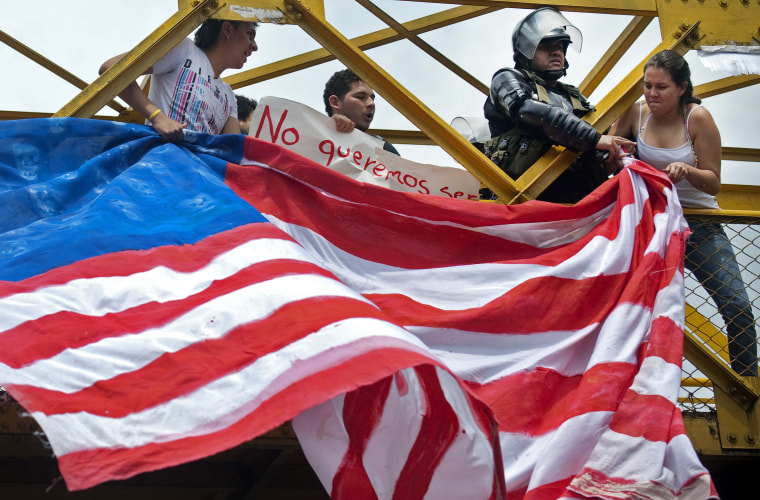 Activist fights for a U.S. flag with a police officer during a protest on April 13 at University of Antioquia in Medellin. They were protesting the VI Summit of the Americas in Cartagena, Colombia.