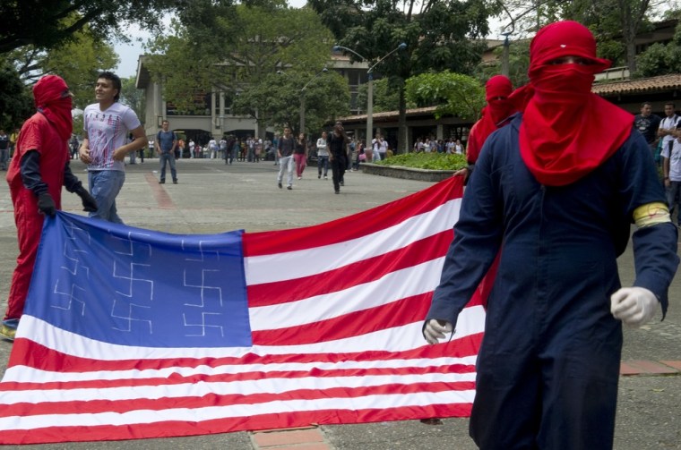 Protesters carry a U.S. flag decorated with swastikas April 13 at Antioquia University in Medellin, Colombia, during a demonstration against the VI Summit of the Americas.