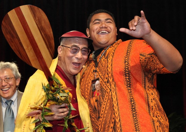Jeremiah Taleni, right, gives a Shaka, a Hawaiian greeting gesture, as he shares a laugh with the Dalai Lama after presenting him with a gift of a paddle from the Kailua High School student body.