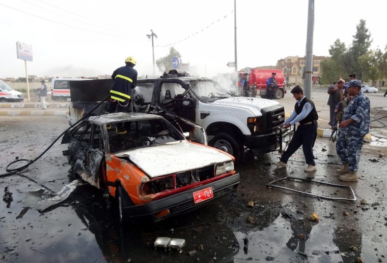 Iraqi firefighters work at the site of a bomb attack in Kirkuk, north of Baghdad, Iraq, Thursday.