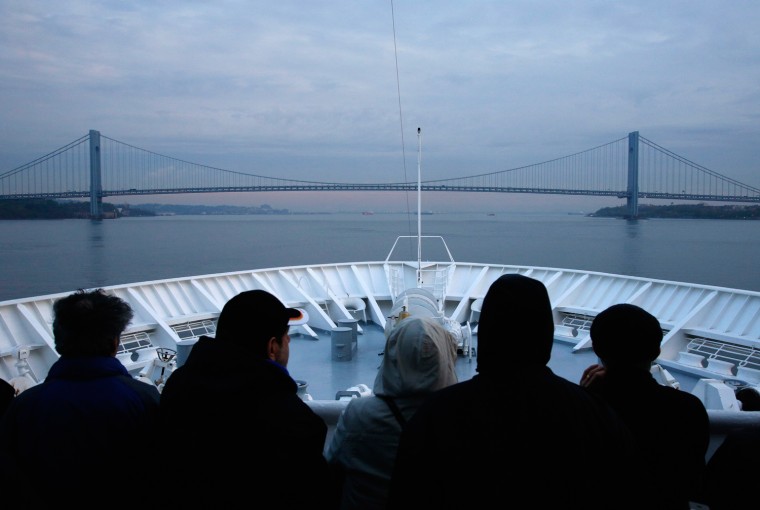 Passengers aboard the Titanic Memorial Cruise ship MS Balmoral look on as they approach the Verrazano-Narrows Bridge at dawn while arriving in New York City on April 19. The ship had sailed from Southampton, retracing the route of the ill fated Titanic liner which sank after hitting an iceberg 100 years ago.