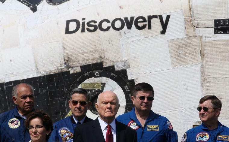 Retired senator-astronaut John Glenn is surrounded by other space veterans in front of the space shuttle Discovery during its handover to the Smithsonian at the Udvar-Hazy Center in Chantilly, Va., on Thursday. Glenn says the shuttles were