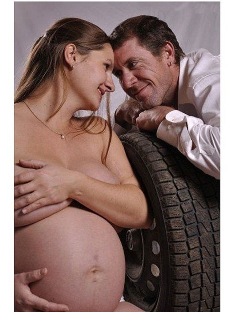 Nothing says pregnancy happiness like posing with your...car tire.