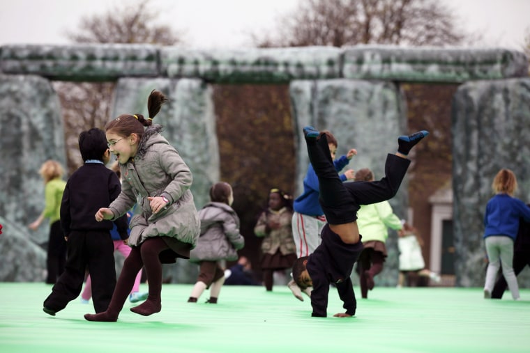 Children play on an interactive piece of artwork by Jeremy Deller, Sacrilege, as it is launched as part of the Glasgow International Festival of Visual Arts at Glasgow Green on April 20, 2012 in Glasgow, Scotland.