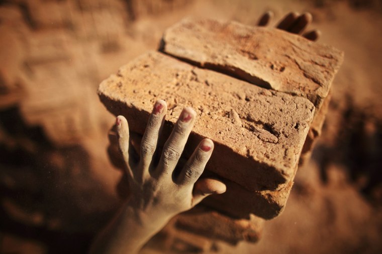 A woman worker holds bricks at a brick factory in Imadol on the outskirts of Katmandu.