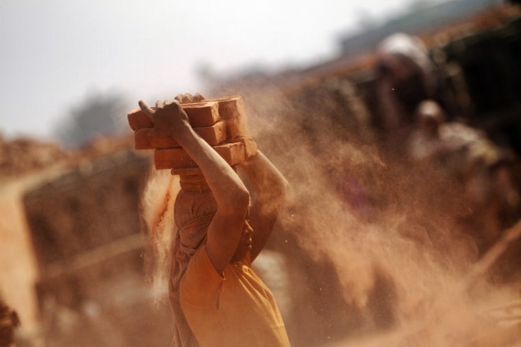 A Nepalese man carries bricks on his head at a brick factory in Imadol.