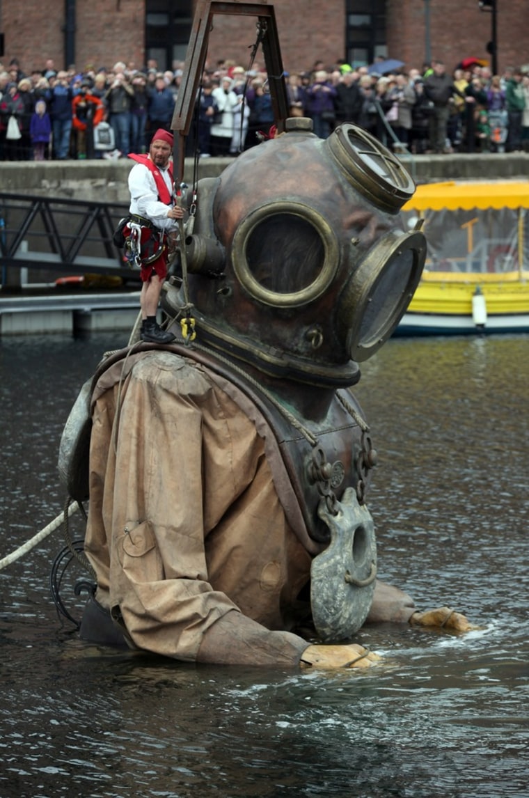 A giant deep sea diver emerges from the Albert Dock to begin a journey through the streets of Liverpool during the Titanic Sea Odyssey on April 20 in Liverpool, England.