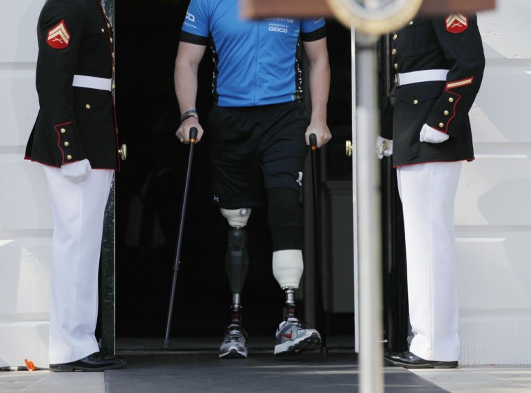 A U.S. soldier injured in conflict walks between a Marine Honor Guard at the White House in Washington D.C on April 20 before the Wounded Warrior Project's Soldier Ride begins on the South Lawn.