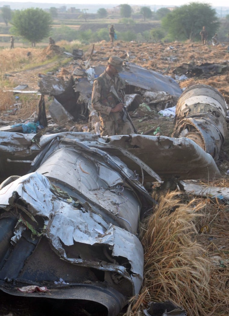 Soldiers inspect the wreckage of the airliner that crashed minutes before landing.