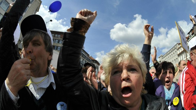 People whistle and shout slogans at the anti-government demonstration organized by trade unions and civic groups in Prague on Saturday.