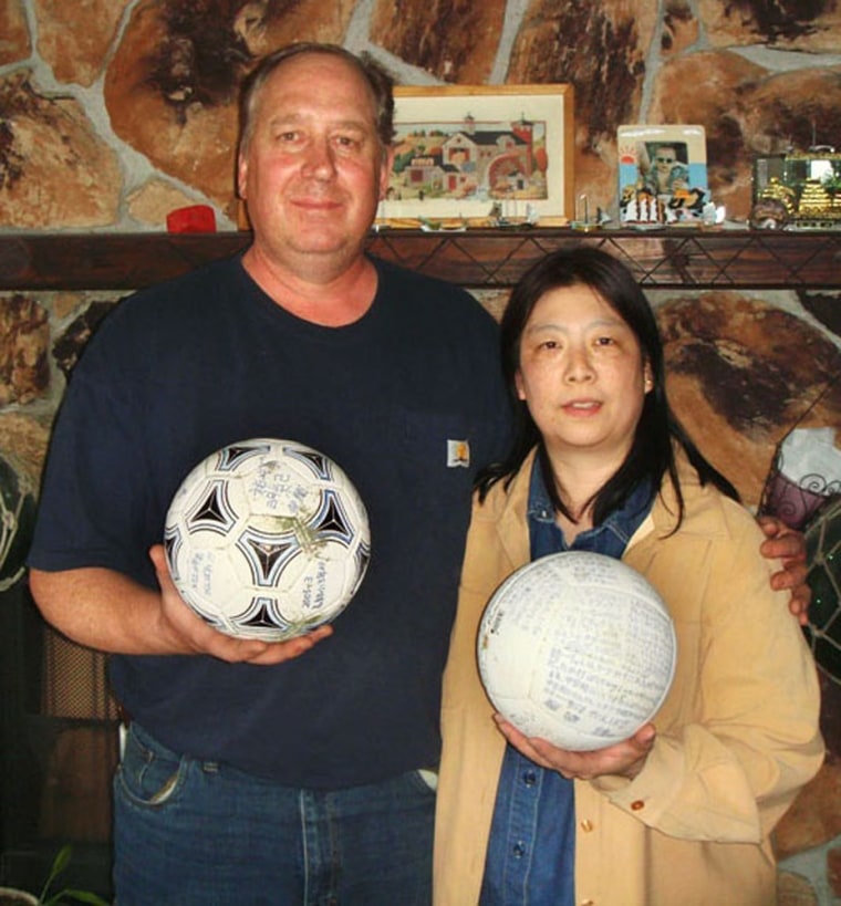 David and Yumi Baxter hold the soccer ball and a volleyball at their home in Alaska. Doug Helton of the National Oceanic and Atmospheric Administration said that there wasn't enough information on the volleyball for Japanese officials to locate its possible owner.