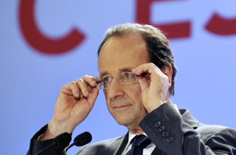 Socialist Party candidate Francois Hollande adjusts his glasses on stage after the announcement of the estimated results of the first round put him in first place.