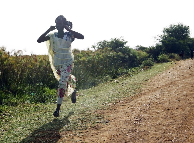 A woman runs along a road during an air strike by the Sudanese air force in Rubkona on April 23, 2012.