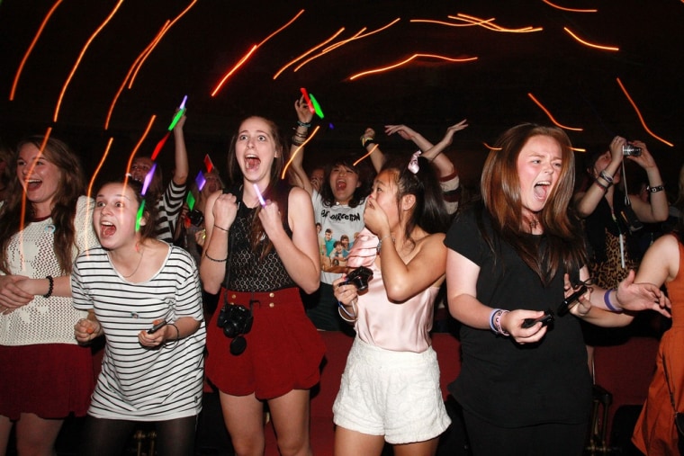 Fans watch One Direction perform live on stage at St James Theatre in Wellington, New Zealand on April 22, 2012.
