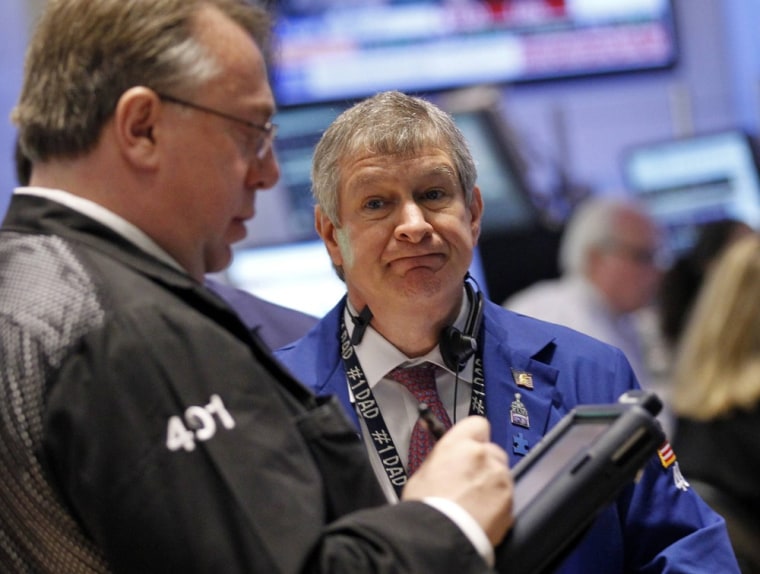Traders work on the floor of the New York Stock Exchange. Stocks fell Monday amid Europe fears.