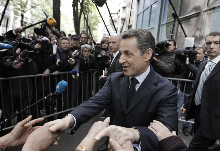 France's incumbent president and Union for a Popular Movement (UMP) candidate Nicolas Sarkozy shakes hands with supporters as he leaves his party's campaign headquarters in Paris after a political committee on Monday.
