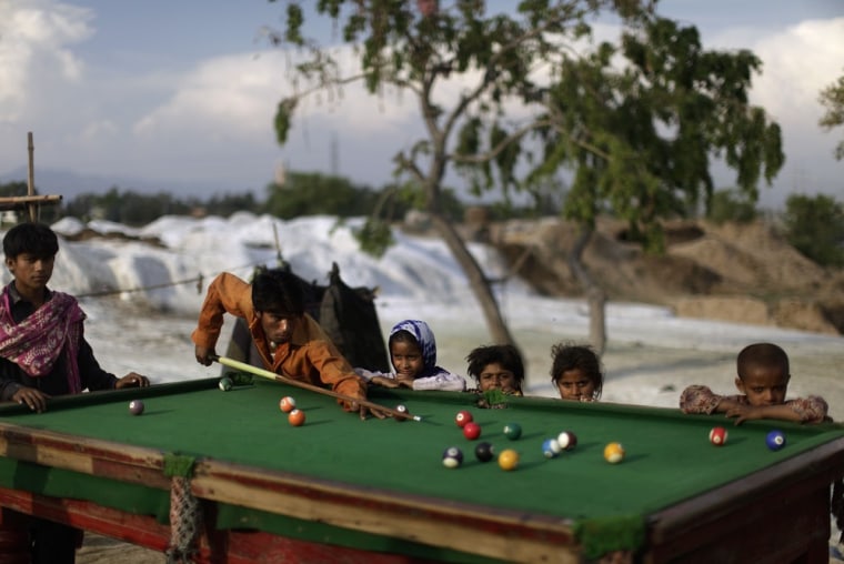 Pakistani men, displaced from a village near Multan by floods in 2010, play a game of pool in a slum on the outskirts of Islamabad, Pakistan on April 24.