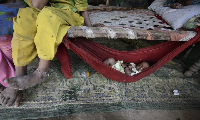 A Pakistani child, whose family was displaced from their village near Multan, Pakistan by floods in 2010, sleeps in a hammock attached in a makeshift tent in a slum on the outskirts of Islamabad on April 24.