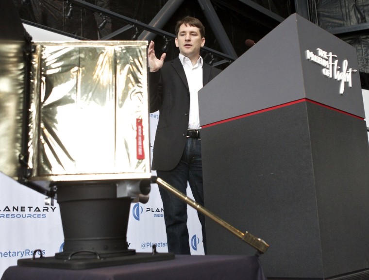 Planetary Resources' president and chief engineer, Chris Lewicki, shows off a full-scale mockup of the Arkyd Series 100 space telescope during a news conference at Seattle's Museum of Flight.