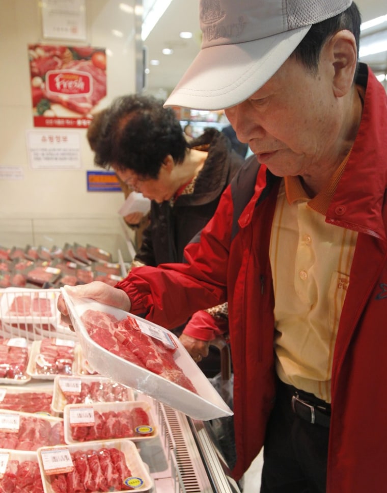 A shopper picks up Australian beef at a Lotte Mart store in Seoul, South Korea, on Wednesday. Lotte Mart was one of two major South Korean retailers to halt sales of U.S. beef.