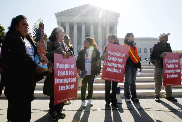 Leonida Martinez, left, from Phoenix, Ariz., and others, take part in a demonstration in front of the Supreme Court in Washington, D.C., Wednesday, as the court questions Arizona's
