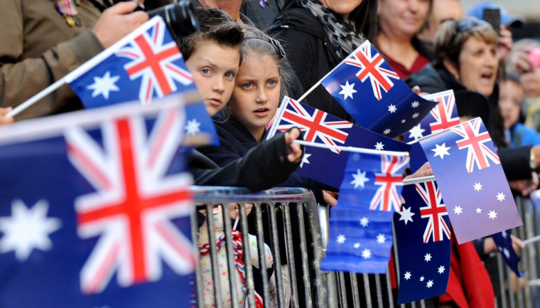 Children watch veterans march through Sydney streets as tens of thousands of Australians and New Zealanders gathered on April 25, 2012 to honor their war dead, attending sombre dawn services and veterans parades in memory of those who fought in war.