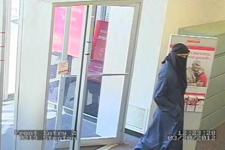 One of two suspects wanted in a series of bank robberies enters a Sovereign Bank in Philadelphia. The two suspects had their faces covered and wore long robes.