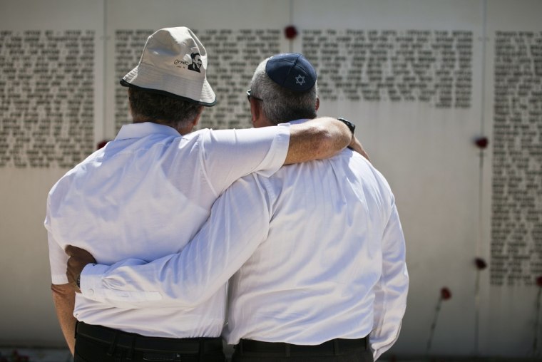 Israelis embrace in front of a memorial engraved with names of fallen soldiers from the armoured corps after a ceremony marking Memorial Day in Latrun near Jerusalem on Wednesday.