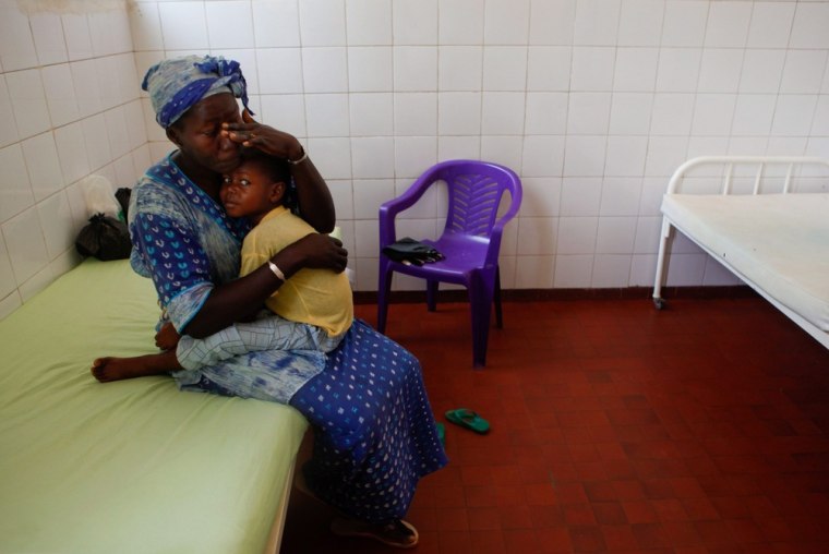 A mother holds her child after being treated at Simao Mendes Hospital.