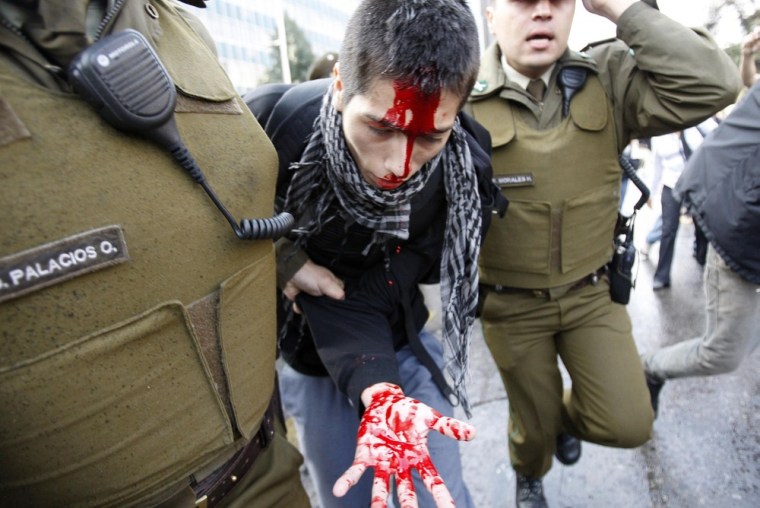 An injured student is arrested by riot policemen during a demonstration against the government in Santiago, Chile on April 25. Chilean students have been protesting against what they say is profiteering in the state education system.