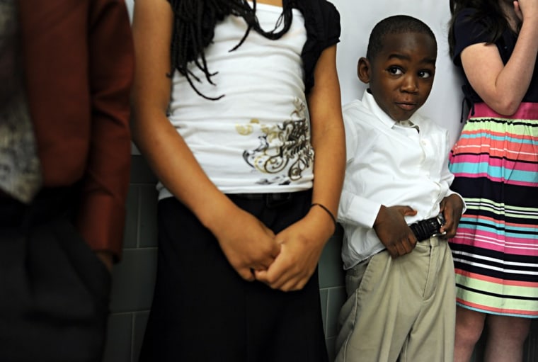 Zyaire McLeod, 5, tucks his shirt in as he prepares to help lead the Pledge of Allegiance at Lee Hall Elementary School in Newport News, Va. on April 25 during a visit by Dr. Jill Biden, Second Lady of the United States. )