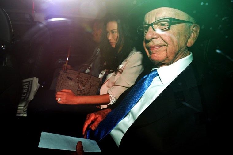 Rupert Murdoch, his wife Wendi Deng and son Lachlan (L) leave their London home on Wednesday.
