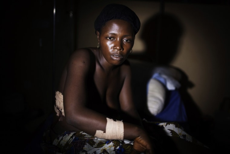 Kadiatu Kauma, 24, sits in a hospital with gunshot wounds to her arm, stomach and back after police opened fire on a crowd of protestors in the mining town of Bumbuna on April 19, 2012. A woman was shot and killed and several others were wounded when police opened fire on a crowd protesting wages and working conditions at the British mining company African Minerals, according to witnesses, hospital staff and police officials.