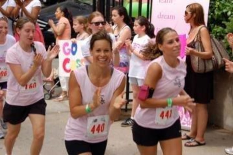 Jenna Wolfe grins at the camera as she races in a 2011 Girls on the Run 5K, an event that pairs adult \"running buddies\" with preteen girls who've spent weeks training to run the 3.1 miles. (Jenna's buddy isn't in this picture -- she's just ahead, crossing the finish line!)