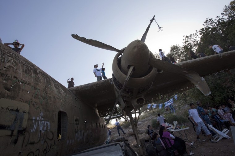 An Israeli family enjoys a picnic underneath the wing of an old military transport plane in The Defender's Forest, near Kibbutz Nachson on Israel's 64th Independence Day. All photo's shot by EPA's Jim Hollander on April 26.