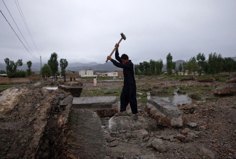 Yasir, 12, uses a hammer to break a concrete block to scavenge for iron from the demolished compound of Osama bin Laden in Abbottabad.