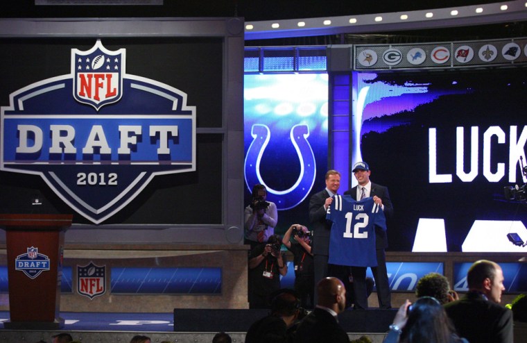 Andrew Luck (R) from Stanford holds up a jersey as he stands on stage with NFL Commissioner Roger Goodell after Luck was selected #1 overall by the Indianapolis Colts in the first round of the 2012 NFL Draft at Radio City Music Hall on Thursday, April 26, 2012 in New York City.