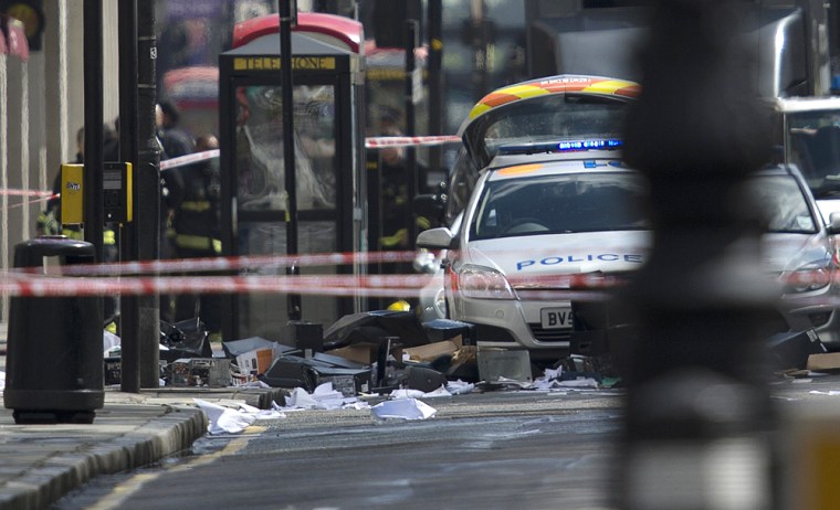 Debris litters the pavement and road in front of police vehicles below an office building were according to reports an armed man was causing a disturbance in central London on Friday.