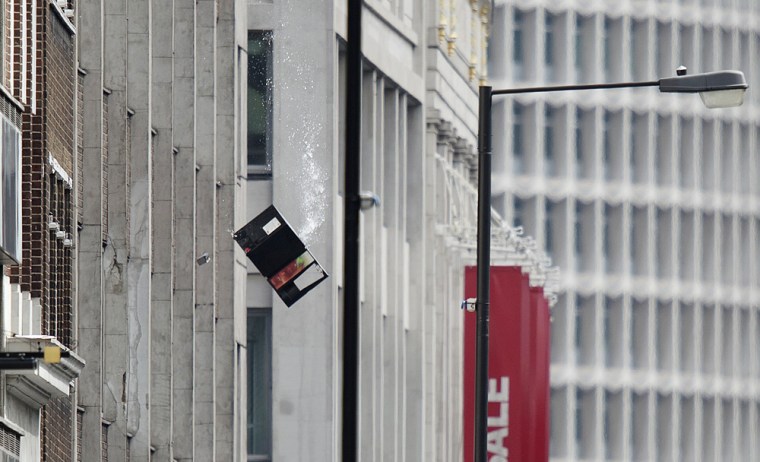 Debris falls from the window of an office building a man was causing a disturbance in central London on Friday.