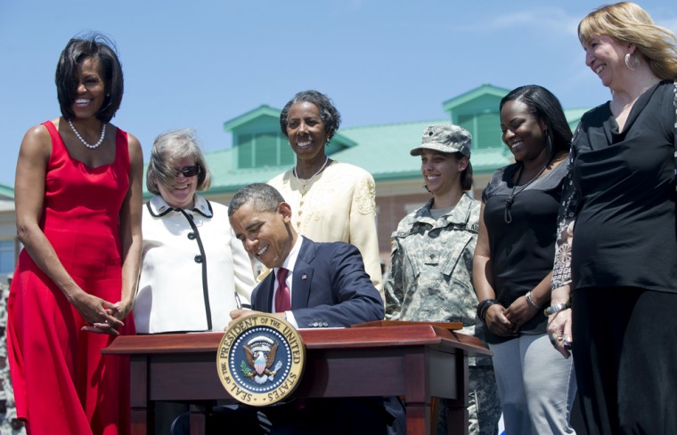 President Barack Obama, alongside Michelle Obama signs an order to protect U.S. service members from deceptive targeting by educational institutions, after speaking to troops at Third Infantry Division Headquarters at Fort Stewart in Hinesville, Ga.