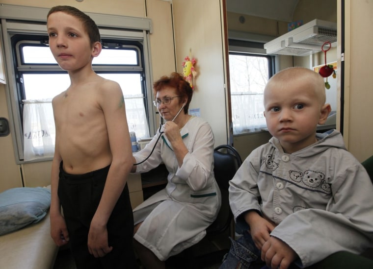 A pediatrician checks two children aboard the Doctor Voino-Yasenecky Saint Luka train at a railway station on April 27 in the town of Zaozyorny, Russia.