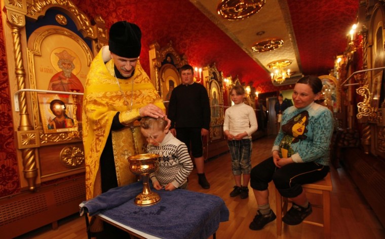 An Orthodox priest baptizes a family at the church aboard the Doctor Voino-Yasenecky Saint Luka train, a free and mobile medical center, at a railway station of the town of Zaozyorny, Russia on April 27. The train also has a carriage that operates as a mobile Orthodox church.