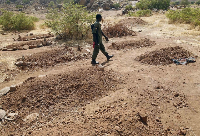 A SPLA-N soldier walks next to fresh graves of Nuba people killed during raids by Sudan's air force in the Nuba Mountains, South Kordofan, Sudan.