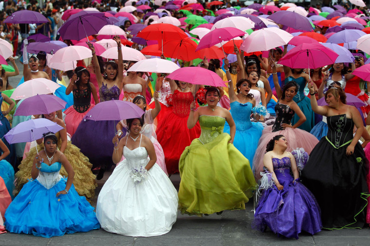 Girls dressed in evening gowns pose for photographs at Zocalo square in Mexico City.
