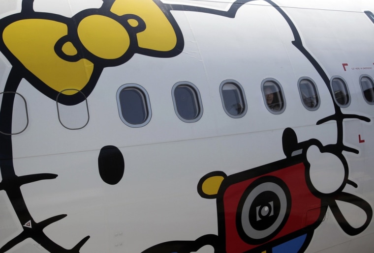 A passenger looks out of an Airbus A330-300 aircraft of Taiwan's Eva Airlines, decorated with Hello Kitty motifs, in Taoyuan International Airport, northern Taiwan, April 30, 2012. Taiwan's second-largest carrier, Eva Airlines, and Japan's comic company, Sanrio, which owns the Hello Kitty brand, collaborated on the second generation Hello Kitty-themed aircraft. There are currently three Hello Kitty-themed Airbus A330-300 aircrafts flying between cities such as Taipei, Fukuoka, Narita, Sapporo, Incheon, Hong Kong and Guam.
