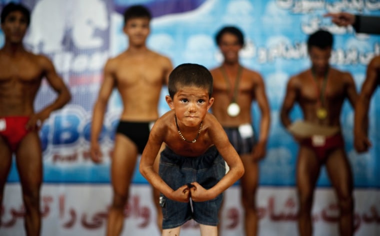 A young boy flexes his muscles during a regional bodybuilding competition in Kabul on April 30, 2012. Bodybuilding is one of the country's most popular sports, even permited during the 1996-2001 Taliban regime.