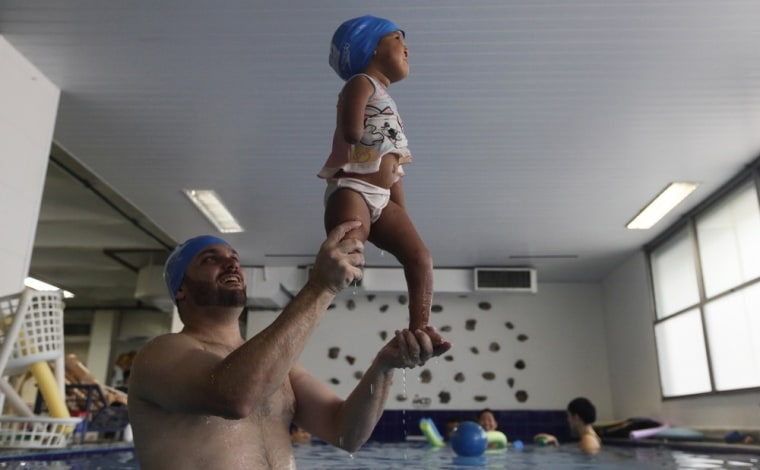 A physical therapist supports Luiza Ezaledo, 2, during a hydrotherapy session on April 2.