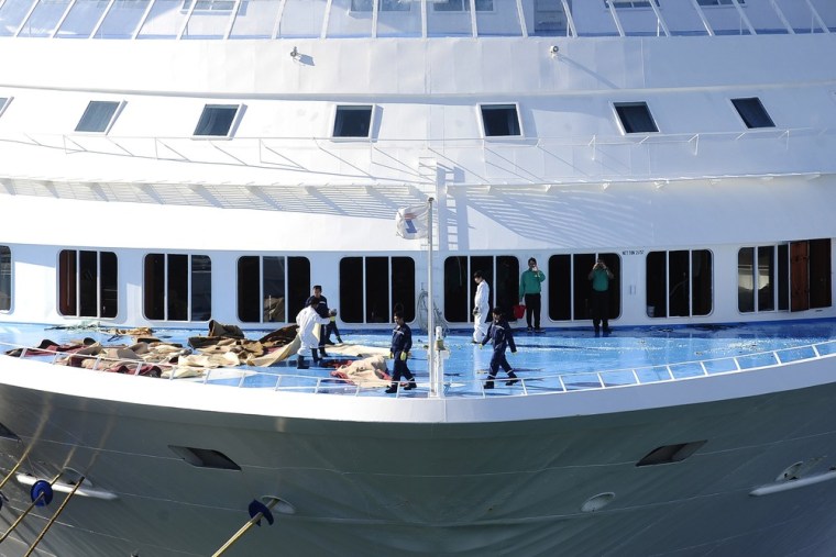 Workers clean up broken windows on the Louis Majesty cruise ship at Barcelona's port on March 4, 2010. Waves of up to 26 feet high smashed into the Mediterranean cruise ship, flooding people's cabins and breaking windows in an ordeal that claimed two lives.