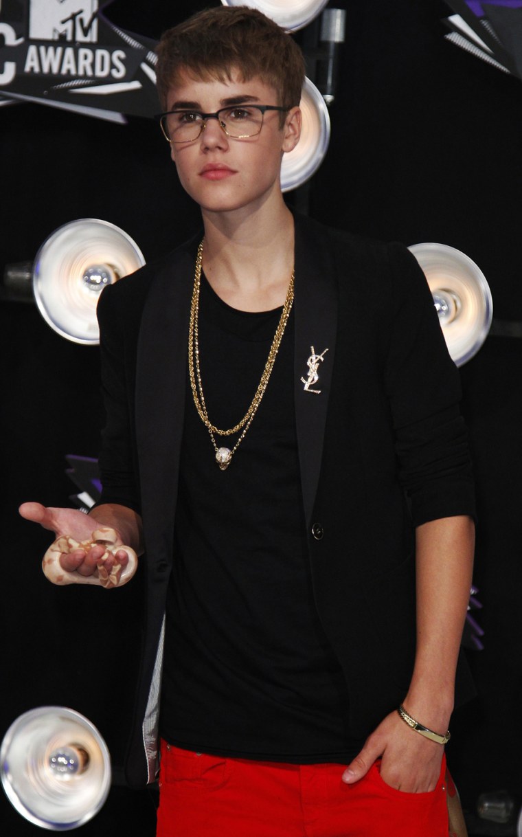 Singer Justin Bieber arrives holding a snake in his hand at the 2011 MTV Video Music Awards in Los Angeles.